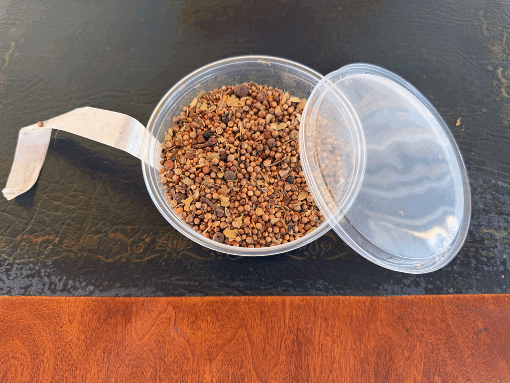 A plastic container of pickling spice.
